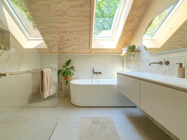 Interieurfoto van badkamer voorzien van dakramen en houten afwerking