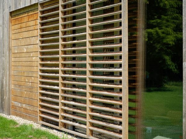 Detail van houten schuifrek voorzien van lamellen tegen zoninstraling