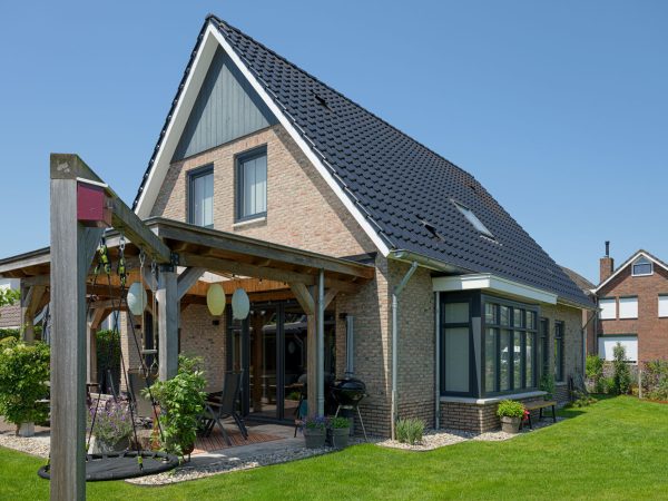 Zijaanzicht van de nieuwbouwwoning voorzien van erker en gemetselde details