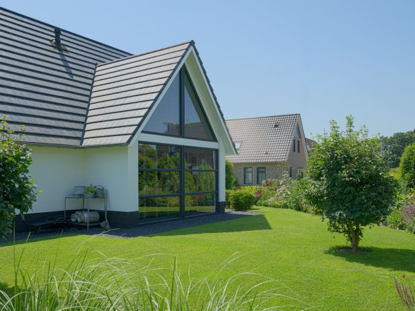 Zijaanzicht van de nieuwbouwwoning met grote glaspartij